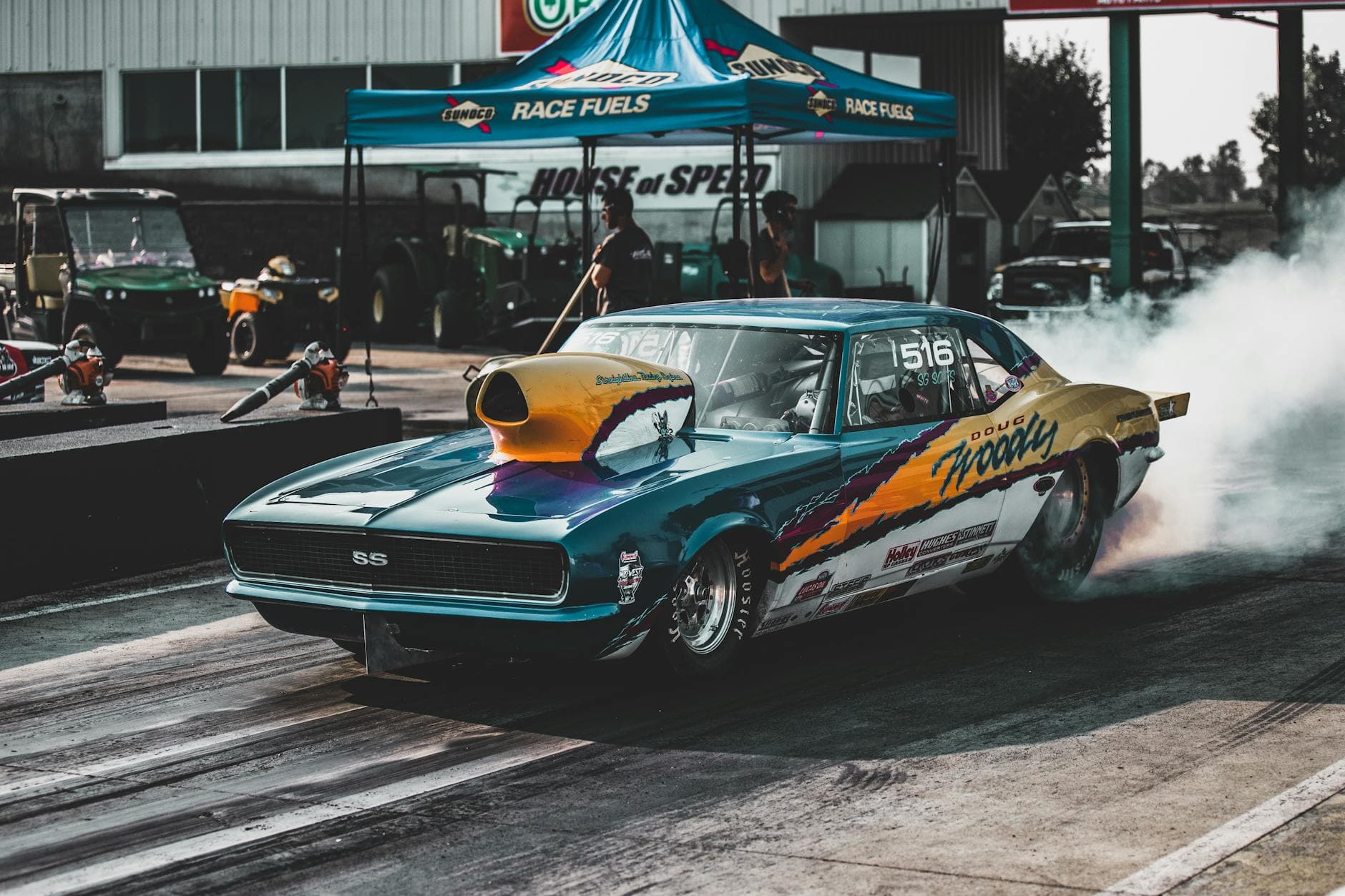 Retro sports car revving up for a race at Topeka drag strip, showcasing power and speed.
