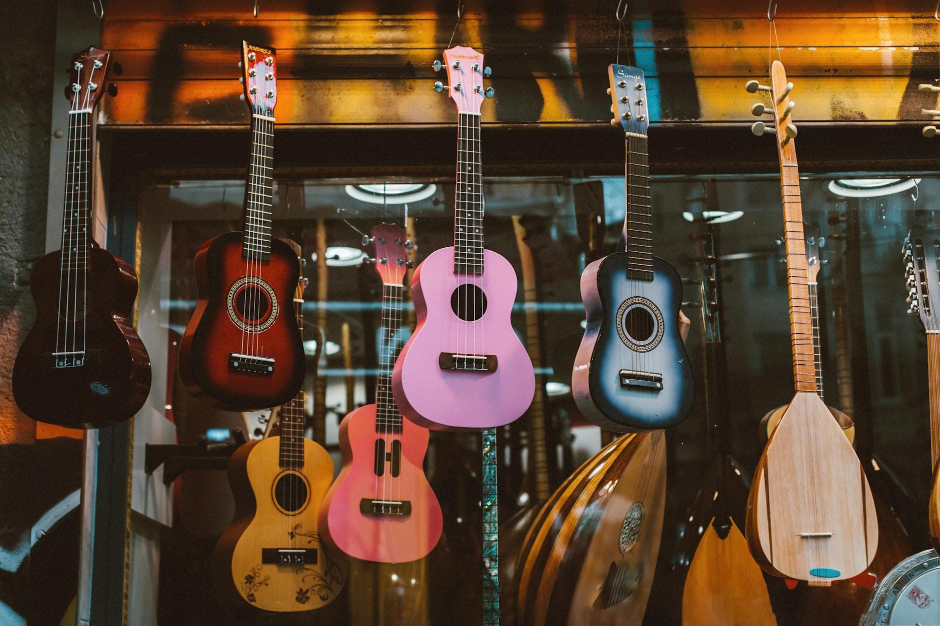 A colorful collection of ukuleles and mandolins hanging in a music store display, enhancing musical ambiance.