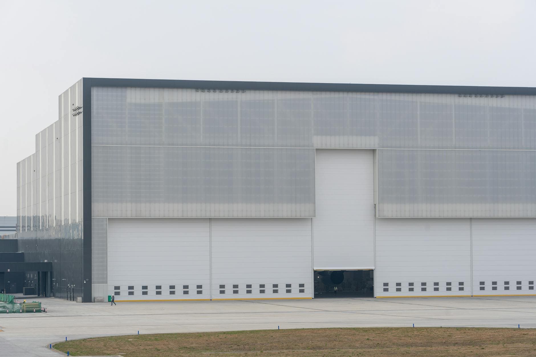 Front view of a large modern warehouse with closed doors, showcasing industrial architecture
