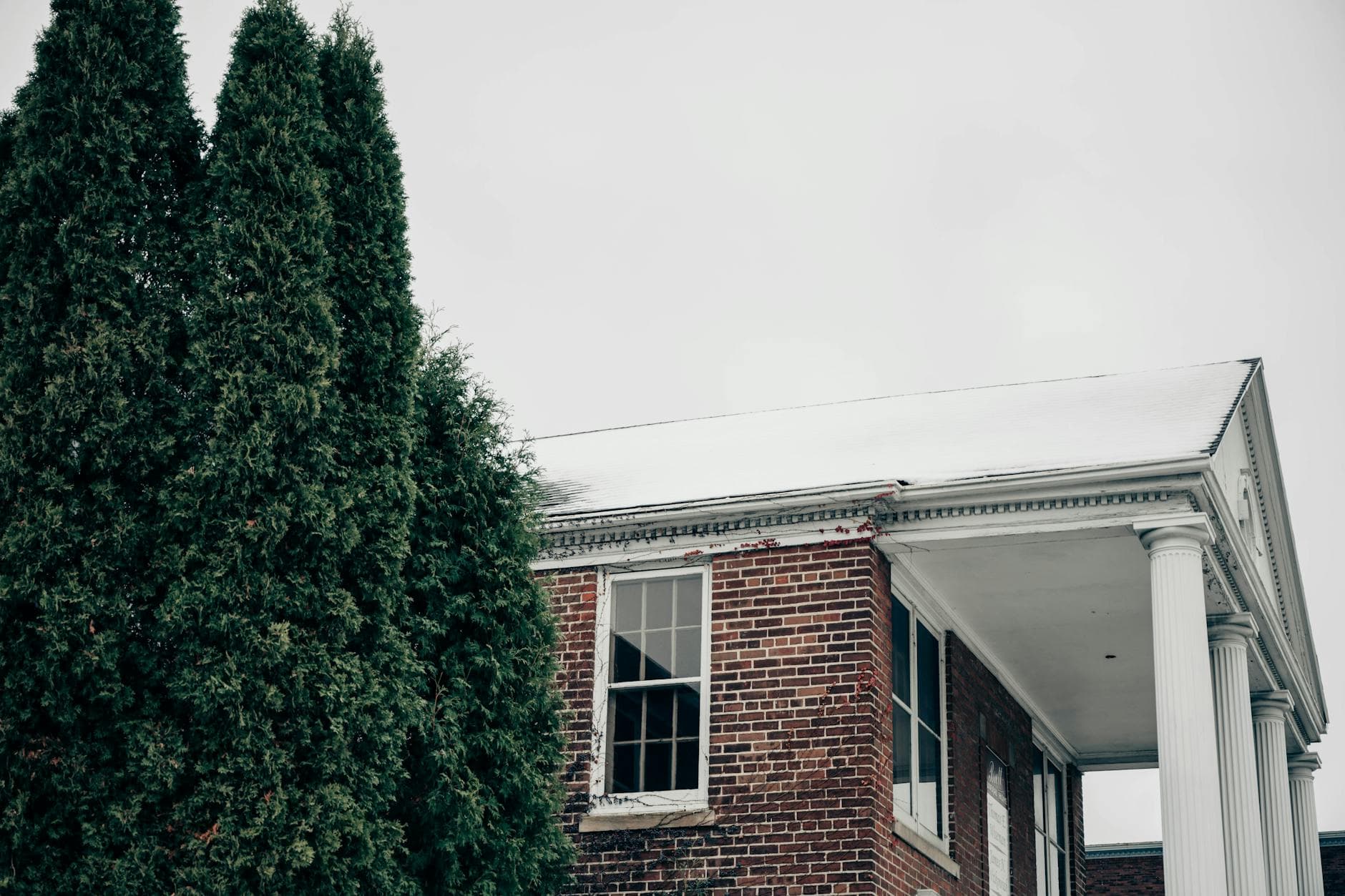 A vintage brick building with columns amidst a snowy landscape in Milwaukee, Wisconsin.