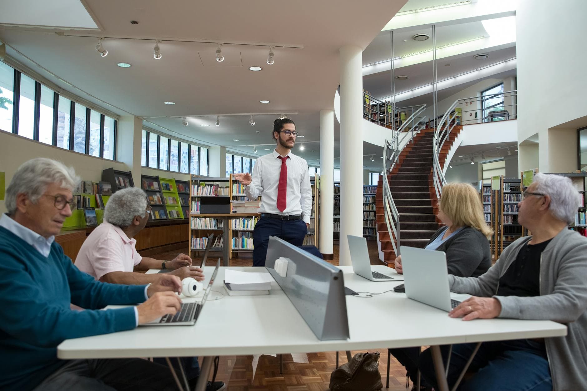 Team engaged in a collaborative meeting in a modern library setting.