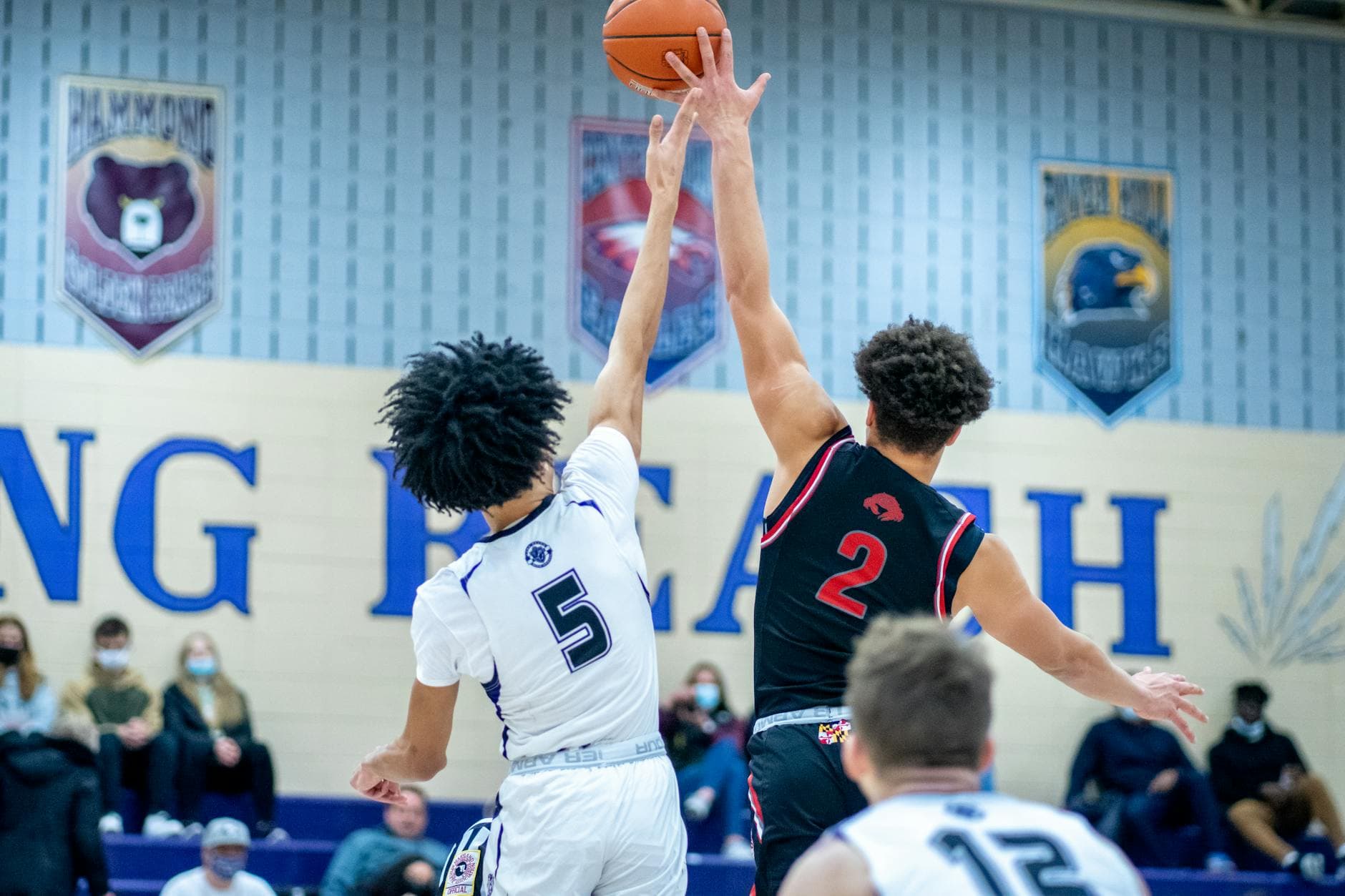 Intense basketball match between teams in a gym, capturing athletic action.