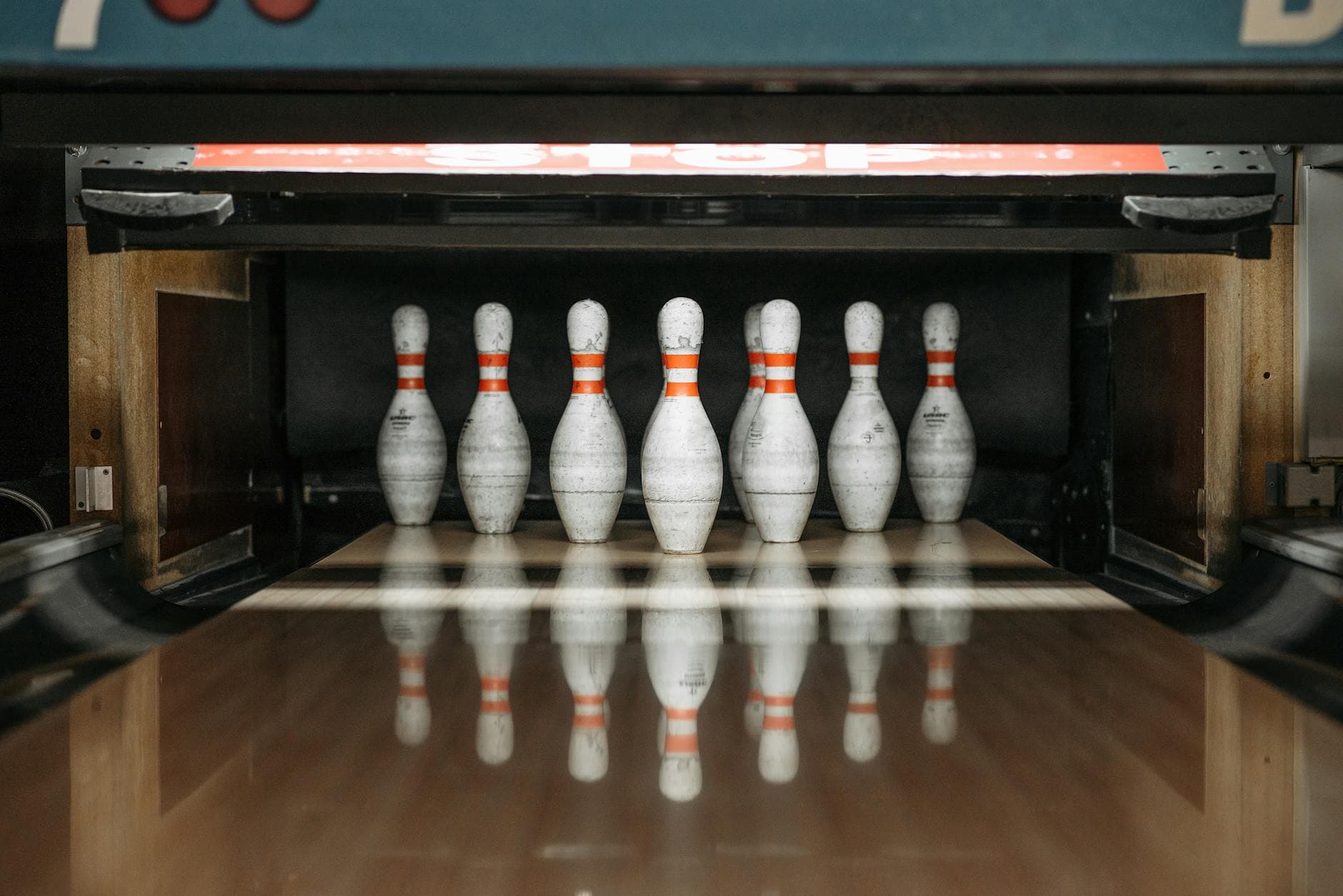 Seven bowling pins arranged in an alley, ready for a game.