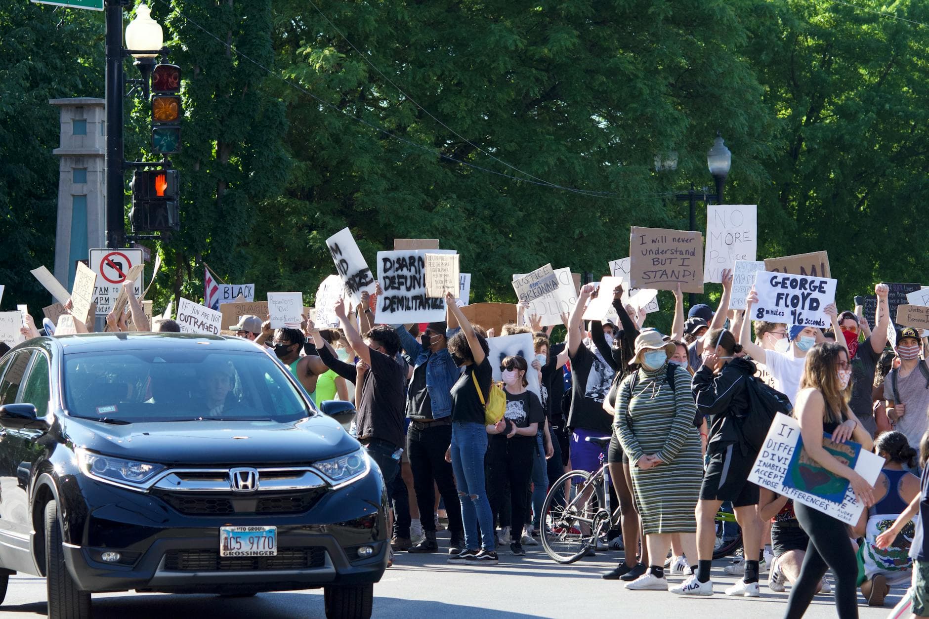 A diverse group of protesters holding signs for social justice at an urban demonstration.