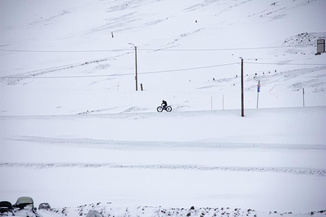person riding on ski lift on snow covered field during daytime