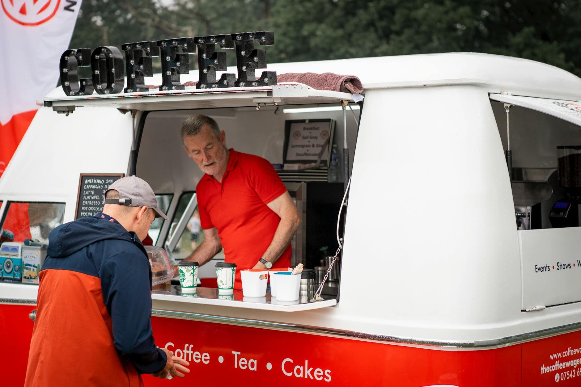 A vintage coffee van serving customers at an outdoor event in Highcliffe, England. Perfect for lifestyle and travel themes.