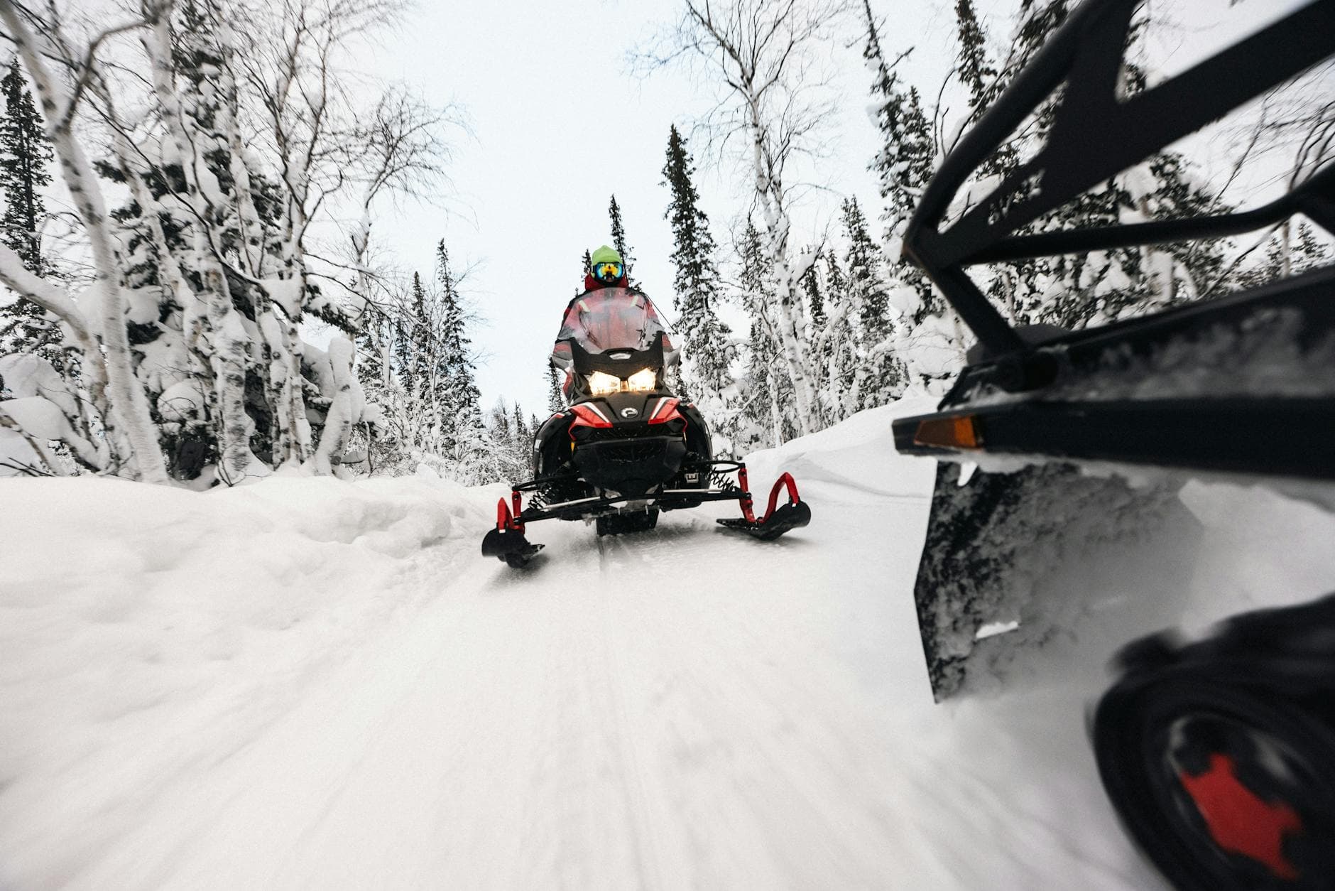 Dynamic snowmobile ride through a snowy forest, capturing the thrill and speed of winter adventure.