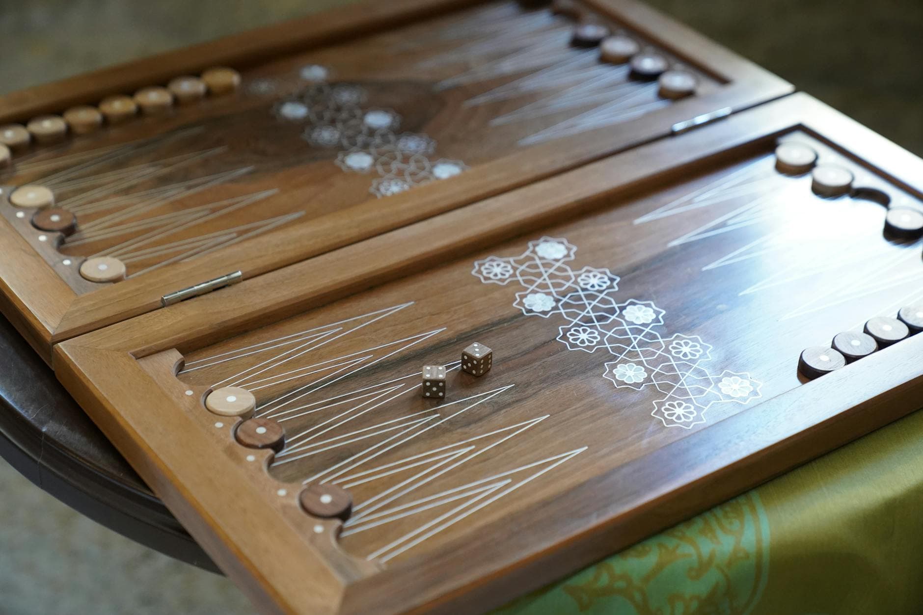 A beautifully crafted wooden backgammon board with dice, ready for play on a stylish table.