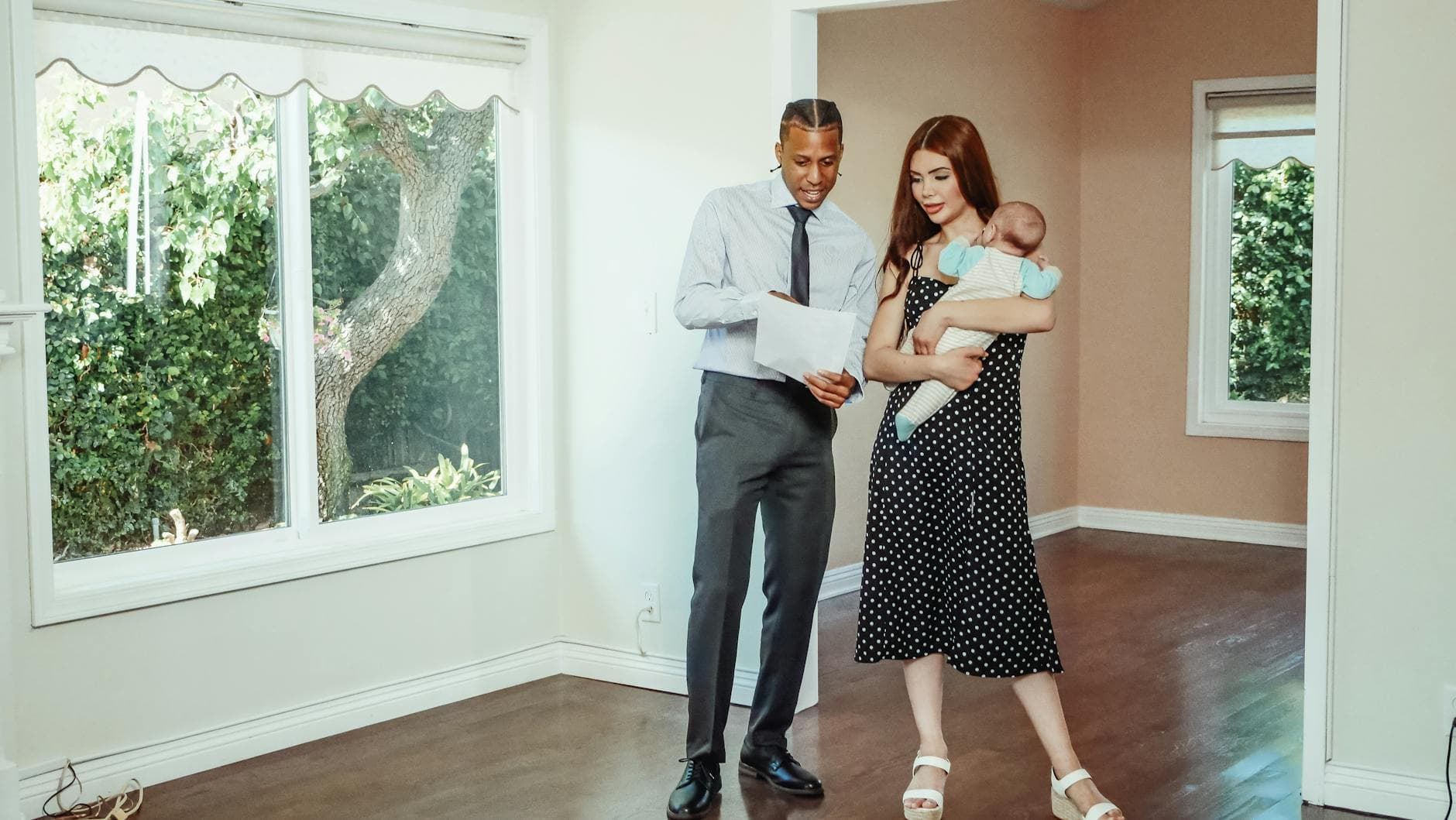A family explores their potential new home with a realtor during a house tour.