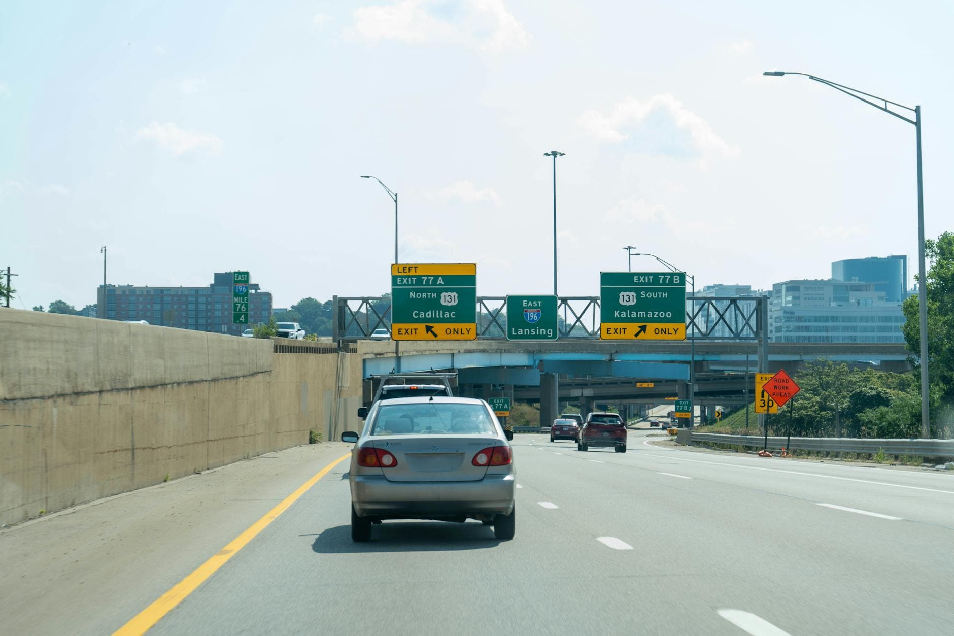 Vehicles travel under a multi-level overpass in Grand Rapids, Michigan, on a clear day.