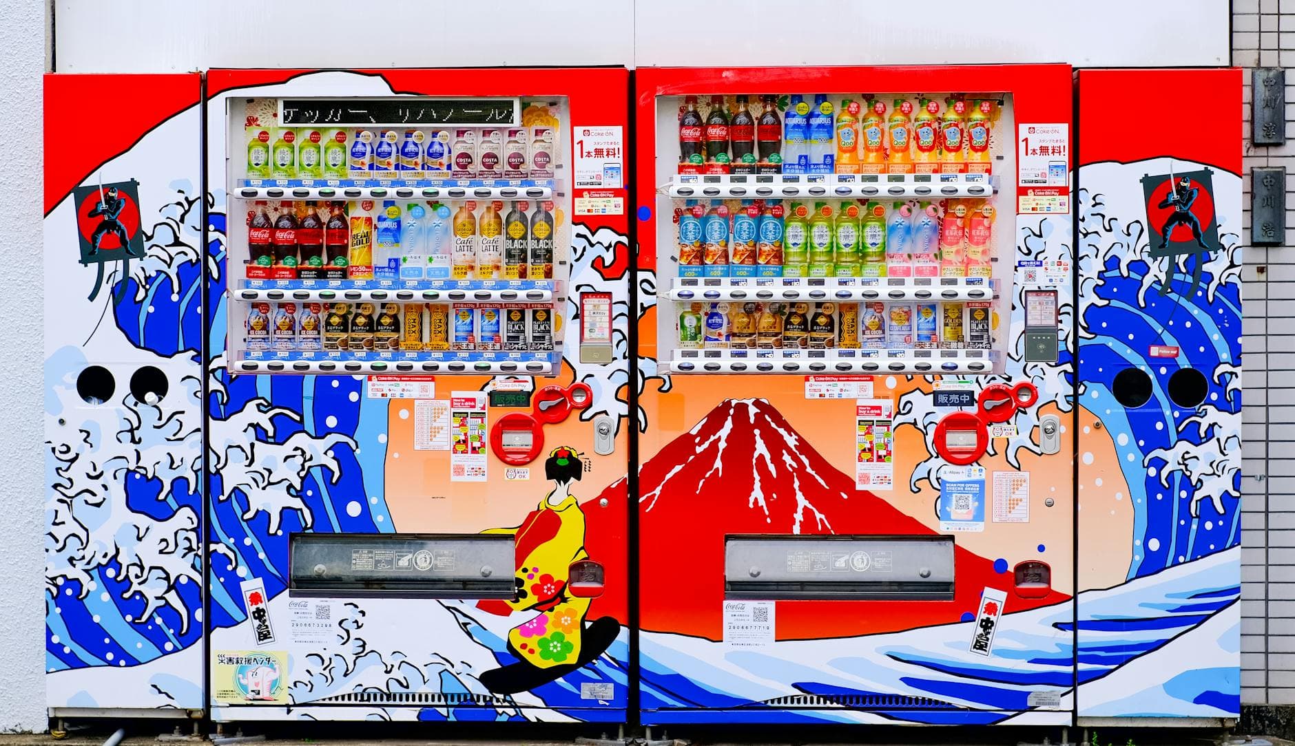 Vibrant vending machines in Japan featuring artistic designs of waves and Mount Fuji.