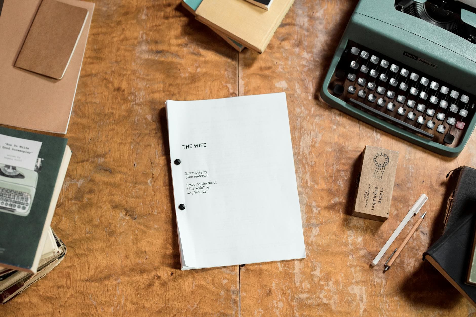 A retro-style desk featuring a typewriter and screenplay manuscript in a top-down view.