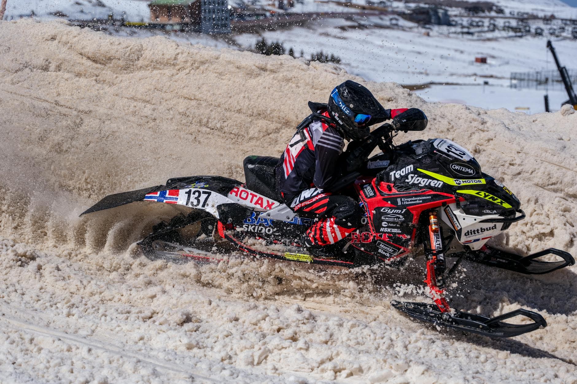 Dynamic snowmobile racing scene showcasing high-speed action on snowy terrain.