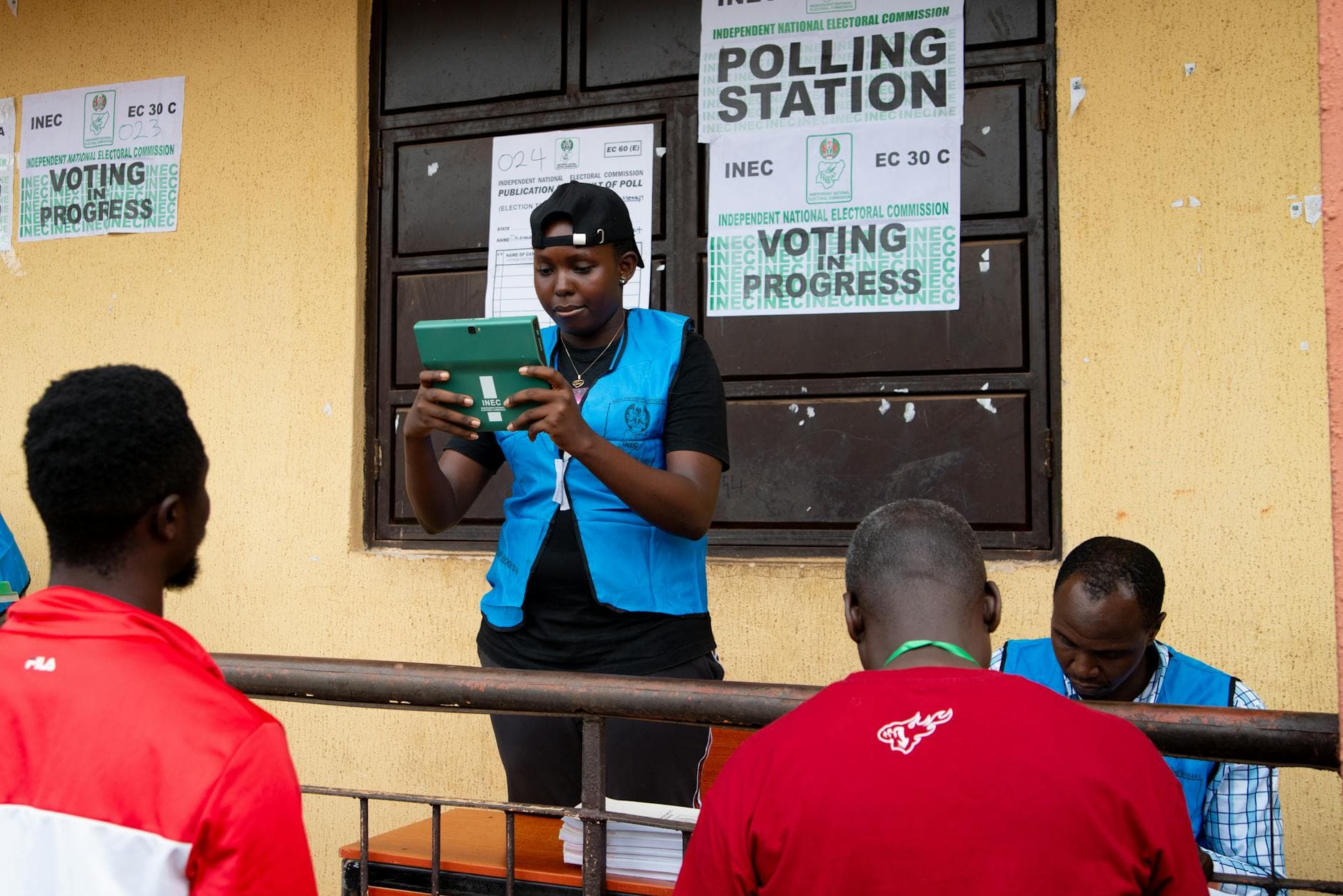 Election official in Nigeria assisting voters on election day at a polling station.