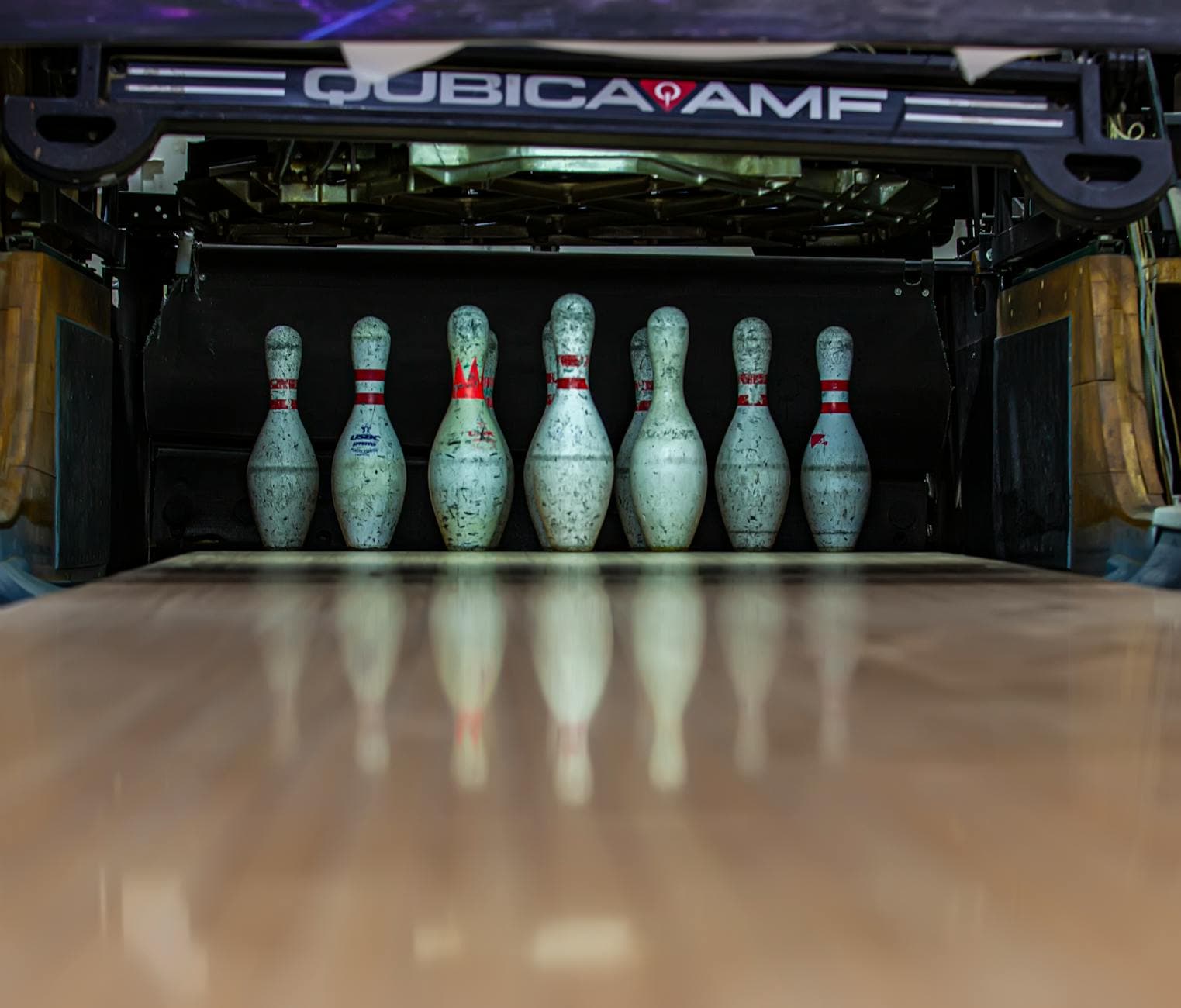 Focused shot of bowling pins set up on a lane, ready for a strike.
