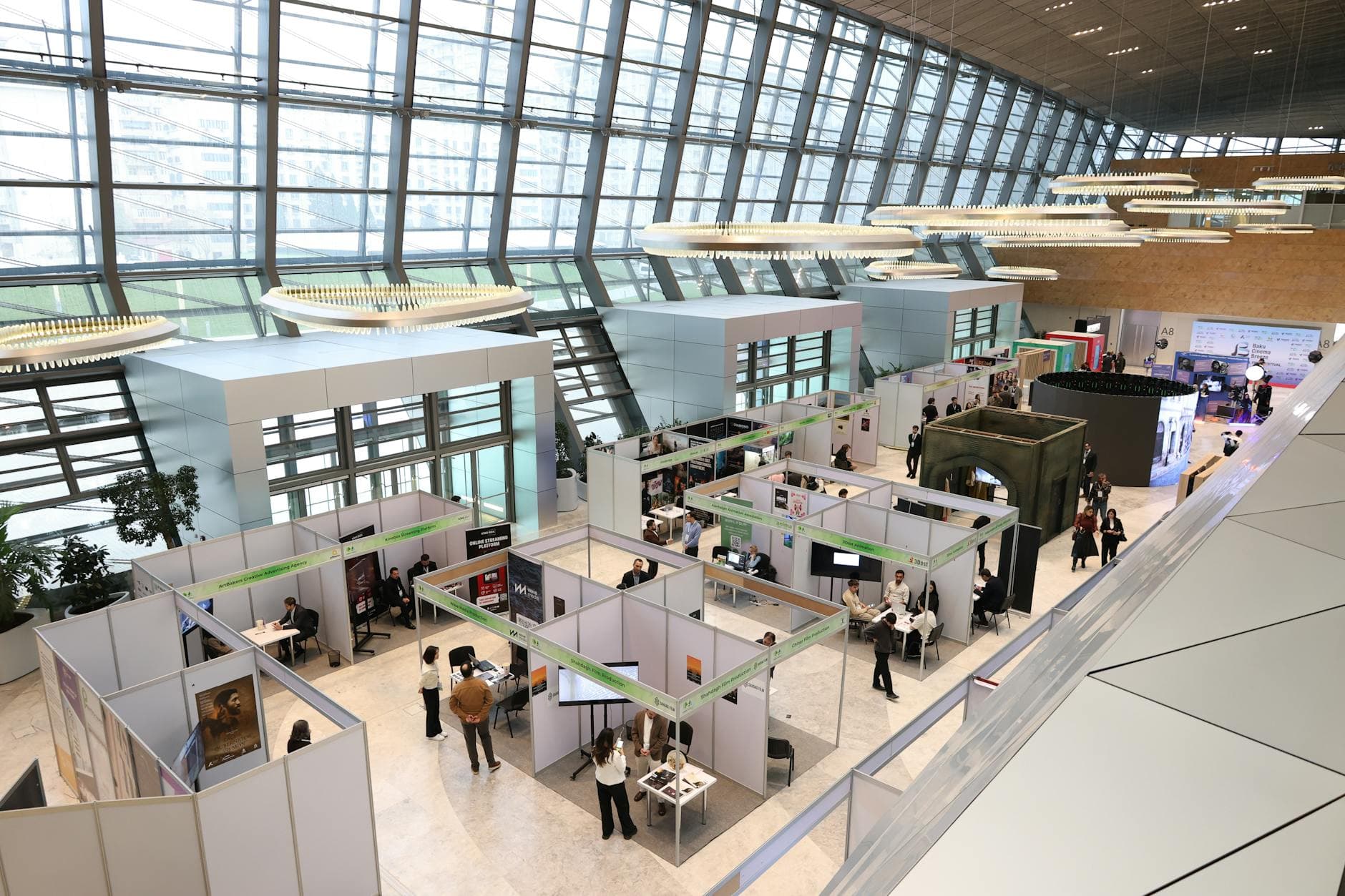 crowded exhibition hall at Rhinelander Hodag Dome with colorful vendor booths and visitors walking between displays