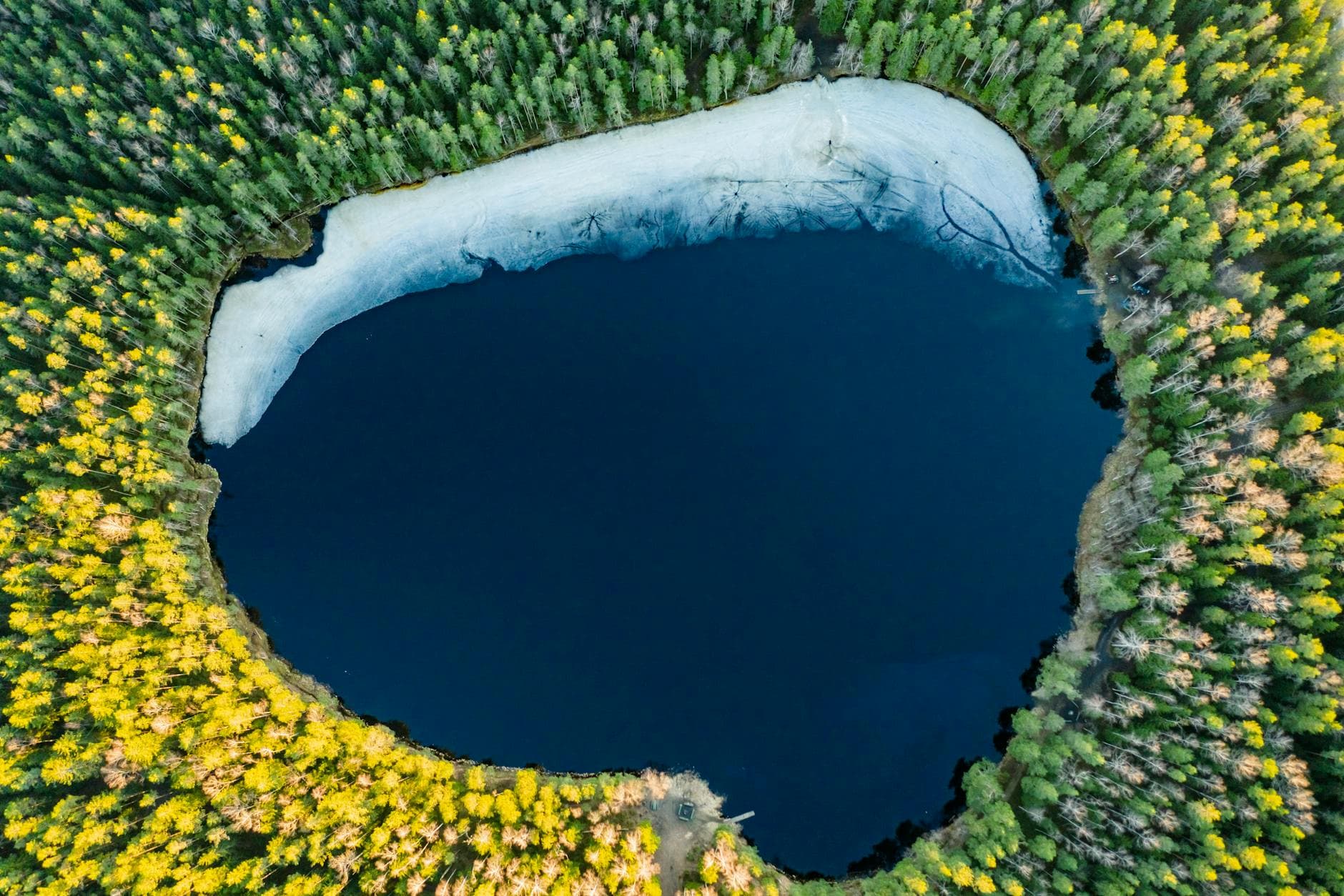 Stunning aerial photo of a forested lake in Latvia during spring.