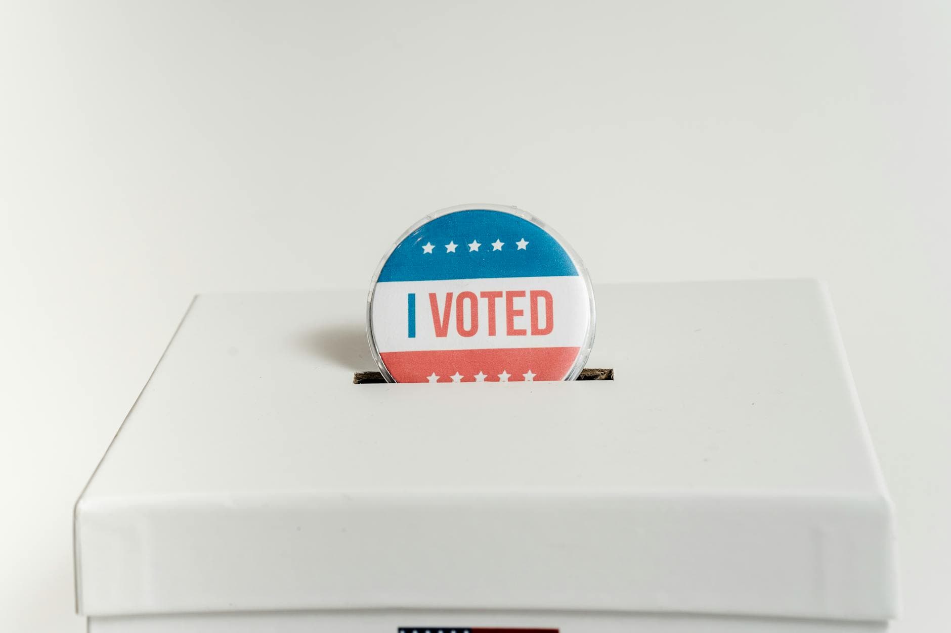 Close-up of an I Voted badge on a ballot box, symbolizing voting in the USA elections.
