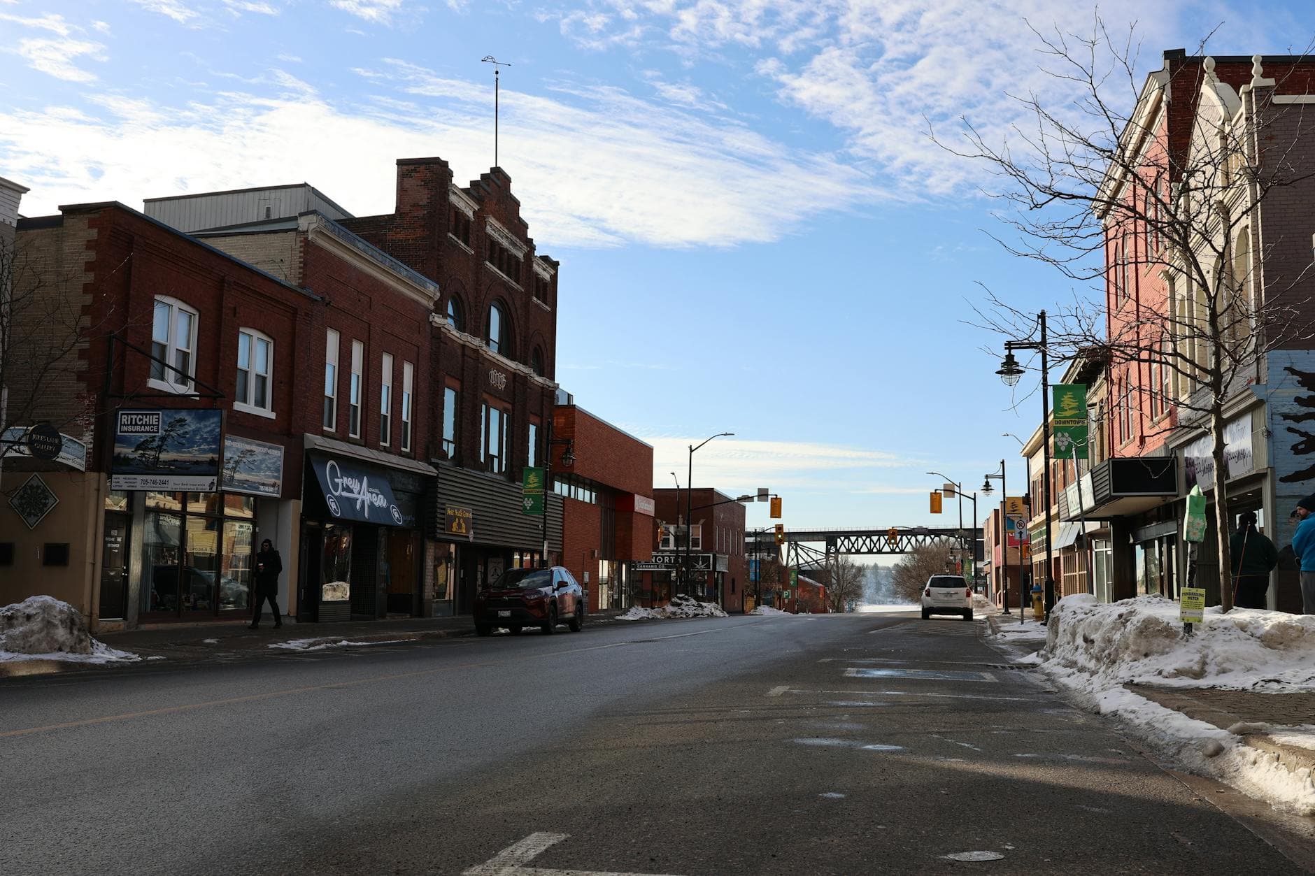 Quaint winter scene of a small town street with historic buildings and a clear blue sky.
