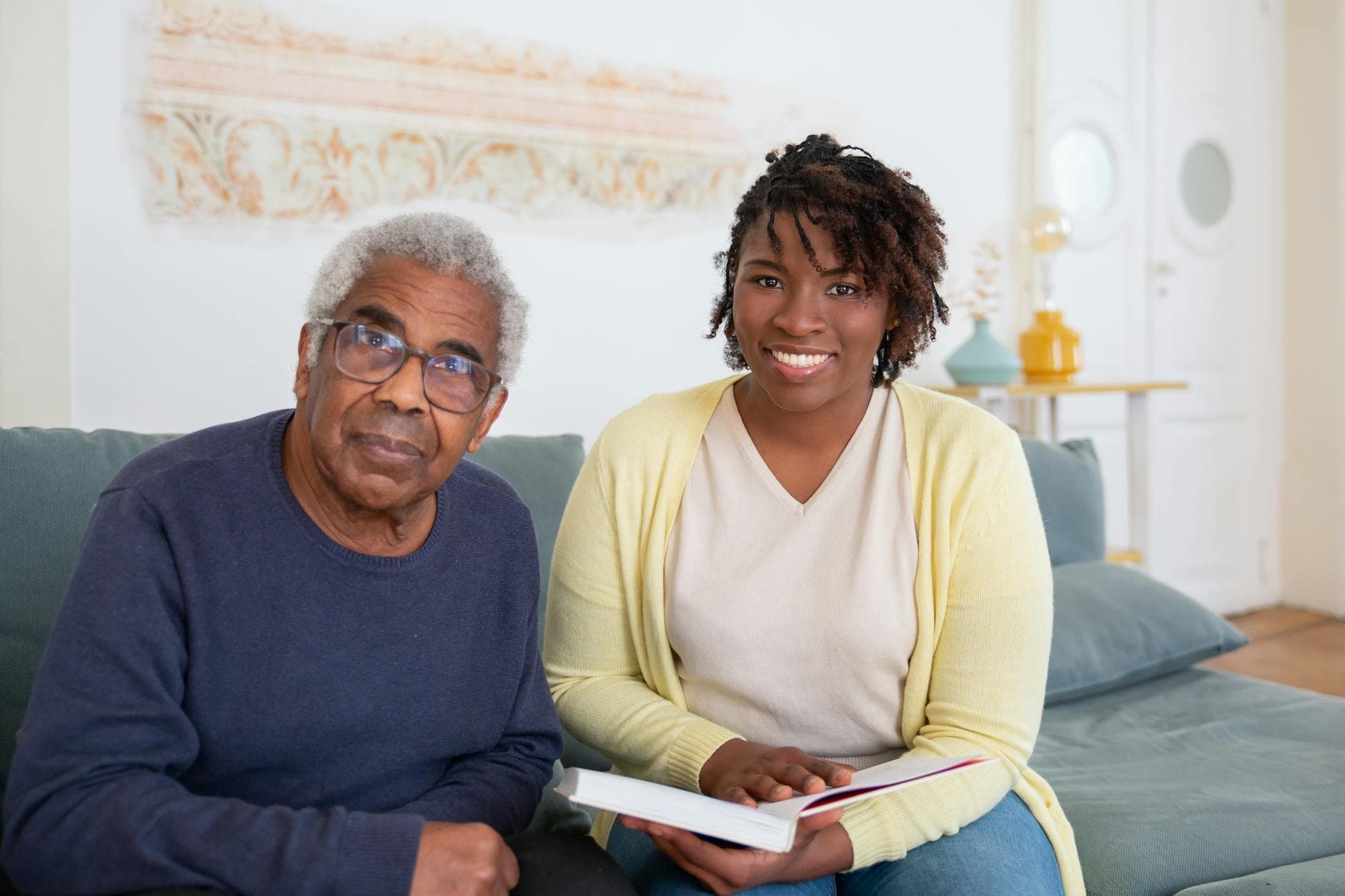 Caring moment between a senior man and a supportive woman at home, fostering connection and well-being.