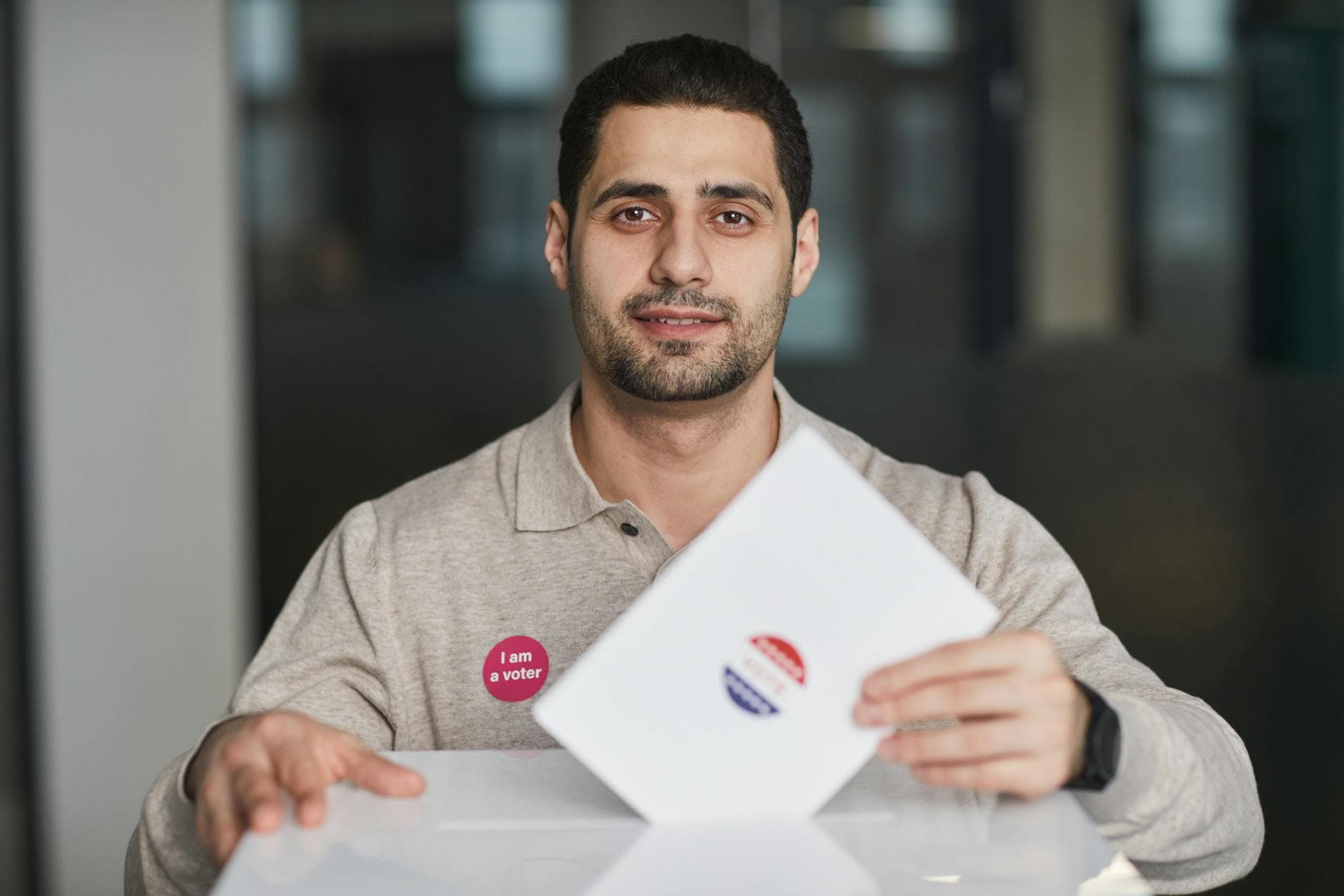 A man with a 'I am a voter' sticker casting his ballot on election day.