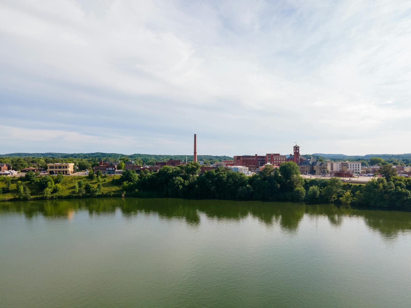 Aerial view of Menomonie, WI featuring the Red Cedar River and cityscape.