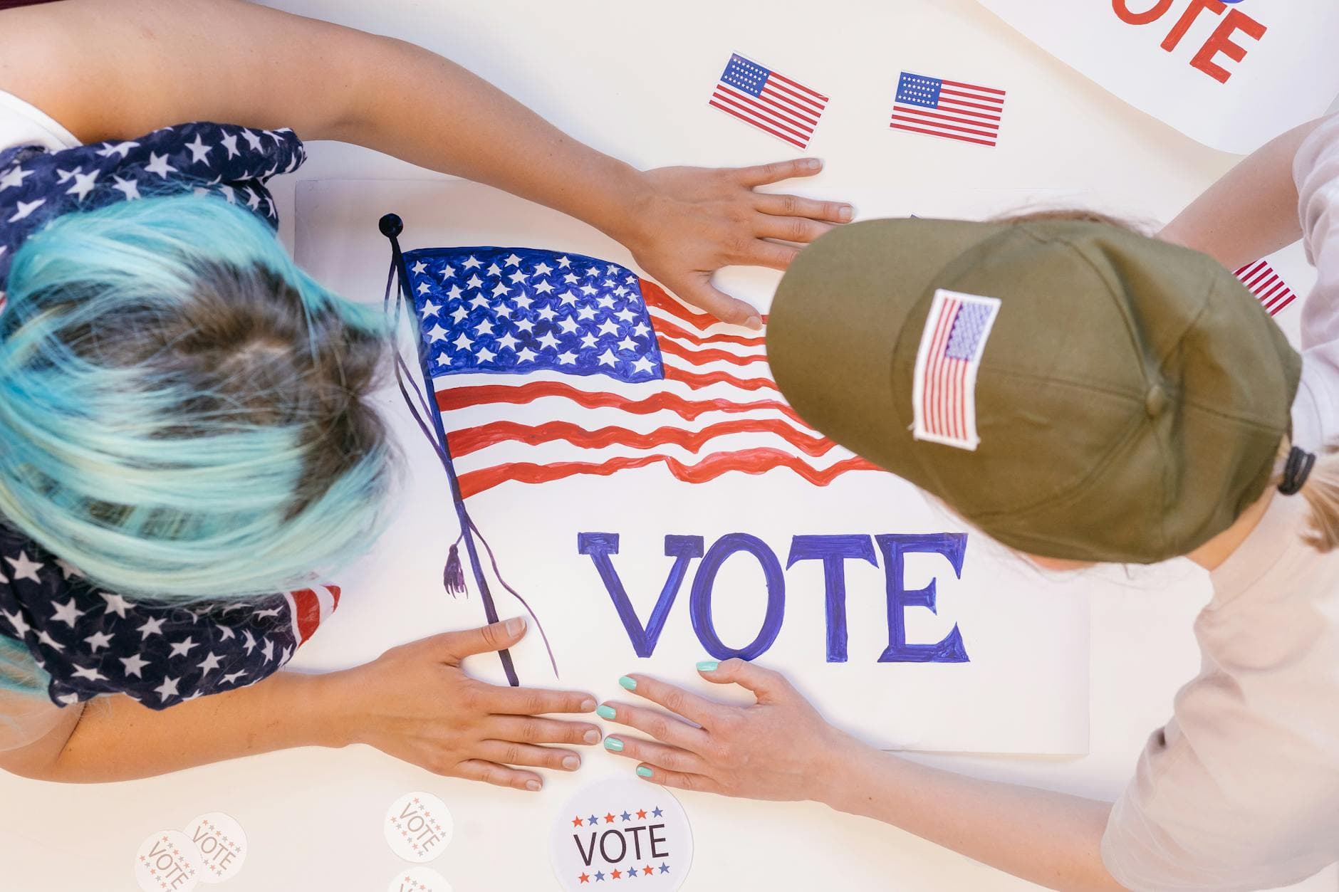 Two individuals preparing voting materials with an American theme to encourage participation.