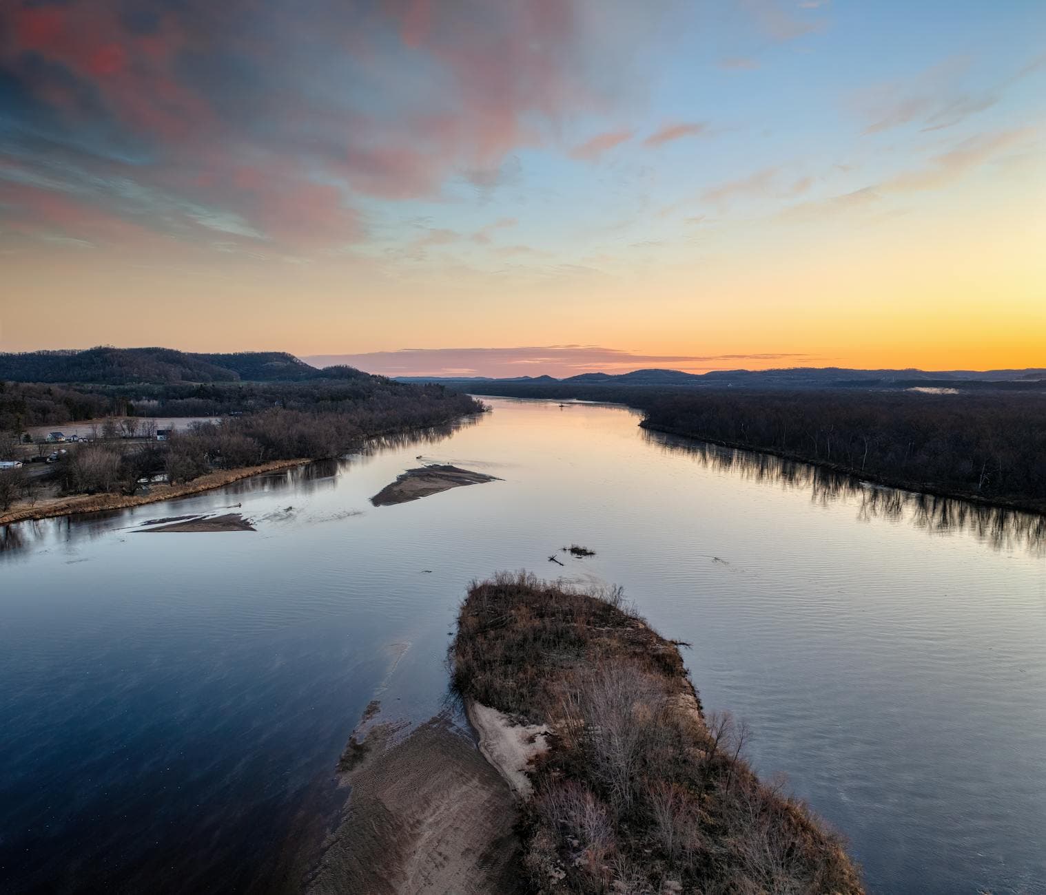 Stunning aerial view of the Wisconsin River flowing through Ella, WI at sunset, surrounded by nature.