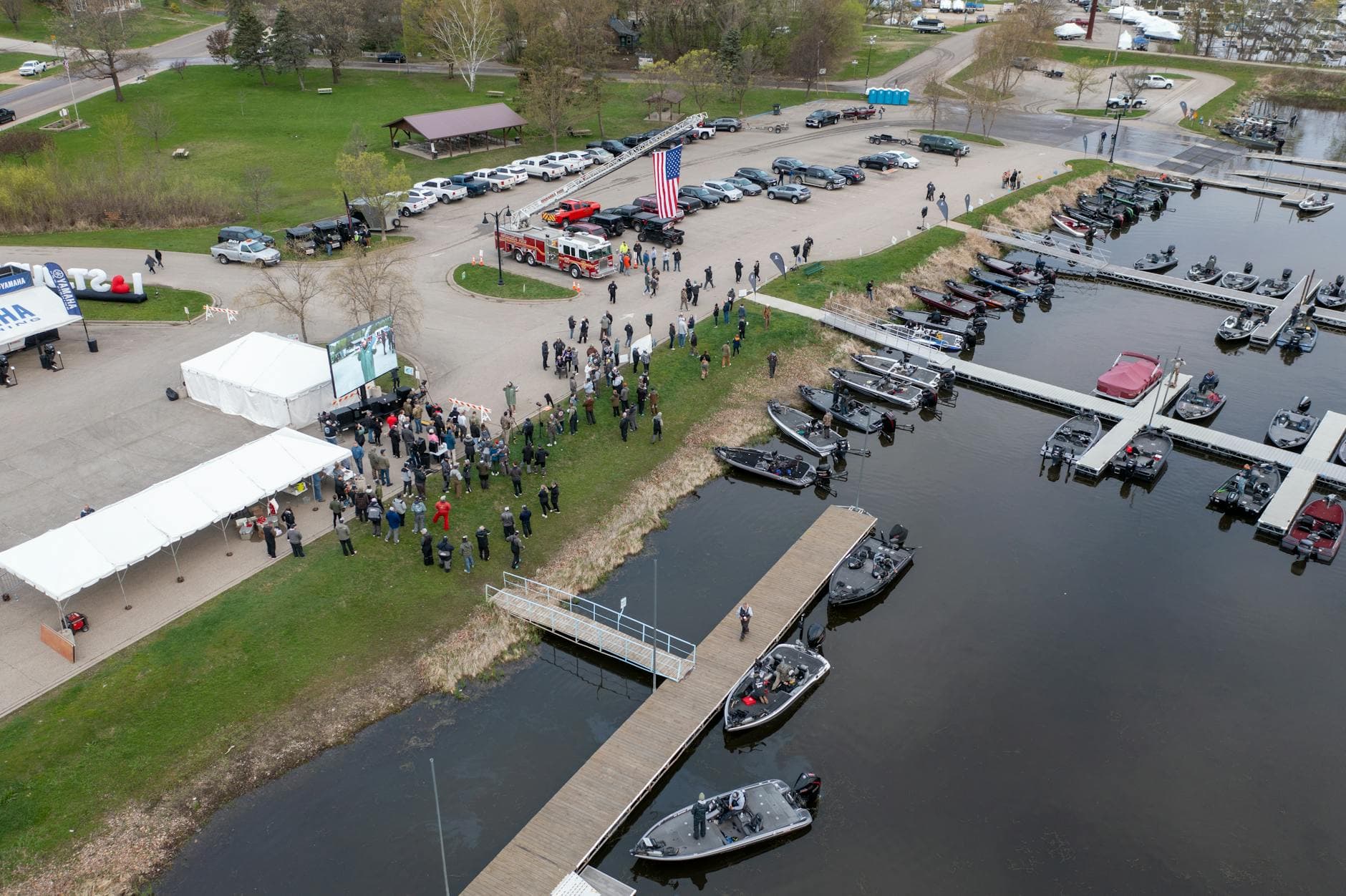 Aerial view of a community gathering at Wabasha Marina with boats and tents.