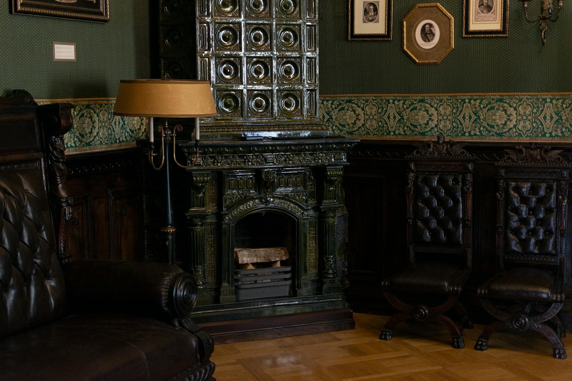 Classic room with a vintage tiled stove and leather furniture, exuding warmth and elegance.