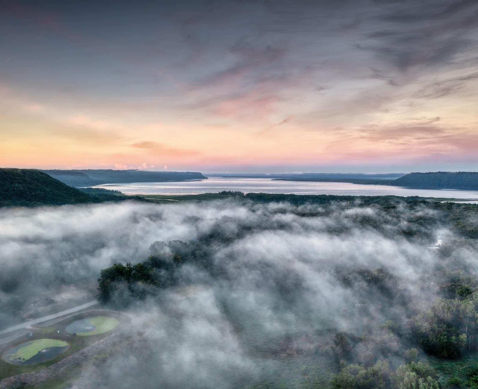 Stunning aerial view of fog rolling over hills at dawn in Maiden Rock, Wisconsin.