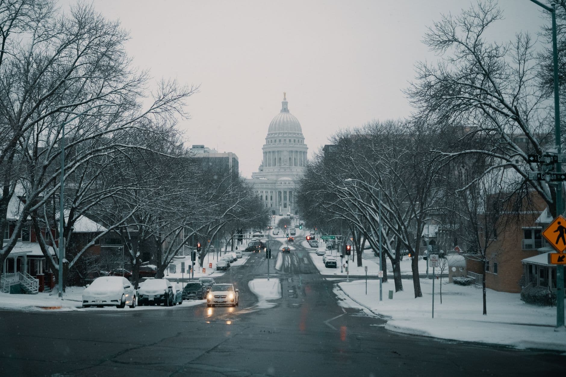 Snow-covered street view with the Capitol building in the background during winter.