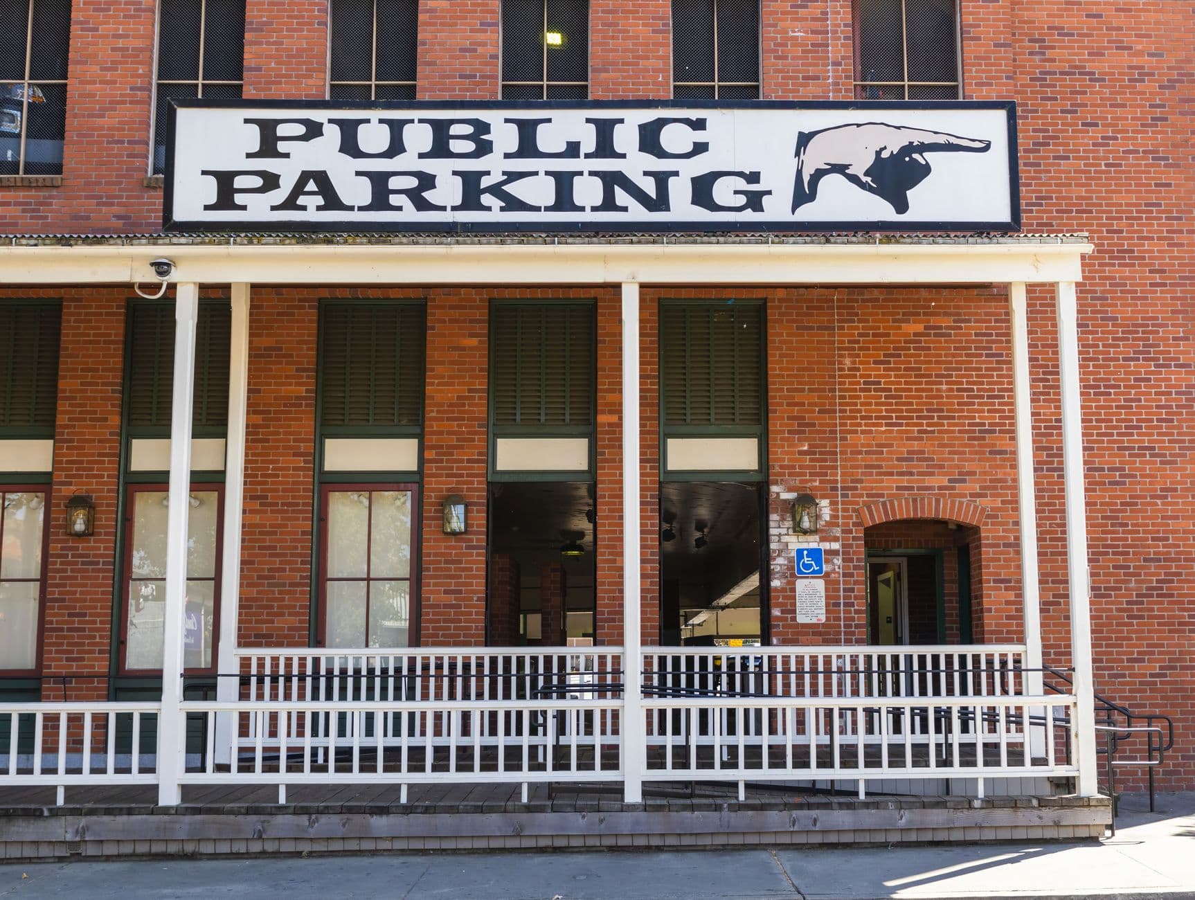 Brick building with a prominent public parking sign and vintage architectural style.